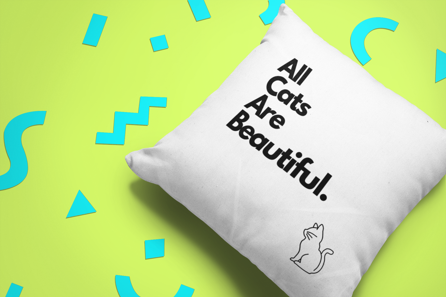 White cushion with black block lettering reading 'all cats are bastards' on a neon green and blue background